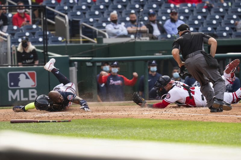 Atlanta Braves' Marcell Ozuna, left, slides safely into home as Washington Nationals' catcher Yan Gomes (10) tries a tag during the fourth inning of a baseball game against in Washington, Thursday, May 6, 2021. (AP Photo/Manuel Balce Ceneta)