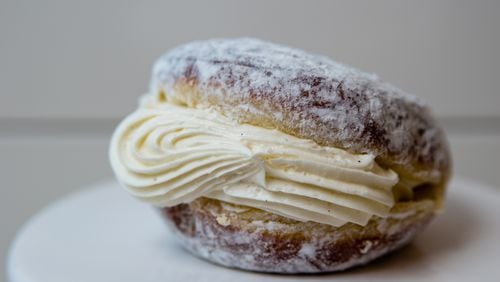 Doughnut Dollies' Sweet Jane, a plain doughnut filled with vanilla cream and covered in powdered sugar, is messy, but worth it. Henri Hollis/henri.hollis@ajc.com