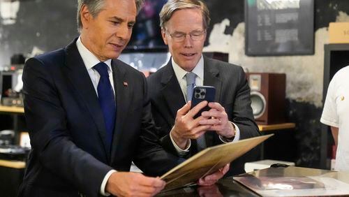 U.S. Secretary of State Antony Blinken and US ambassador to China Nicholas Burns look at a record during a visit to Li-Pi record store in Beijing, China, Friday, April 26, 2024. (AP Photo/Mark Schiefelbein, Pool)