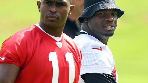 Falcons linebacker Sean Weatherspoon and wide receiver Julio Jones during team practice Tuesday, June 10, 2014, in Flowery Branch. Weatherspoon later left the field after rupturing his Achilles tendon. CURTIS COMPTON / CCOMPTON@AJC.COM
