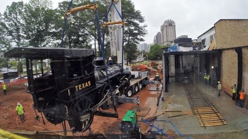 The Texas is lifted by a 110-ton crane to its new home at the Atlanta History Center Thursday after a trip to North Carolina for refurbishing. Famed for its role along with the locomotive the General in the Civil War’s Great Locomotive Chase in 1862, the Texas will be permanently displayed in a glass-walled enclosure that will be illuminated at night and clearly visible from West Paces Ferry Road at all hours. BOB ANDRES / BANDRES@AJC.COM