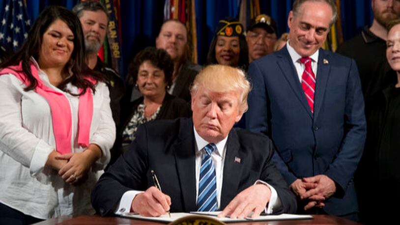 President Donald Trump, accompanied by Veterans Affairs Secretary David Shulkin, center right, and veterans, signs an Executive Order on "Improving Accountability and Whistleblower Protection" at the Department of Veterans Affairs, Thursday, April 27, 2017, in Washington. (AP Photo/Andrew Harnik)