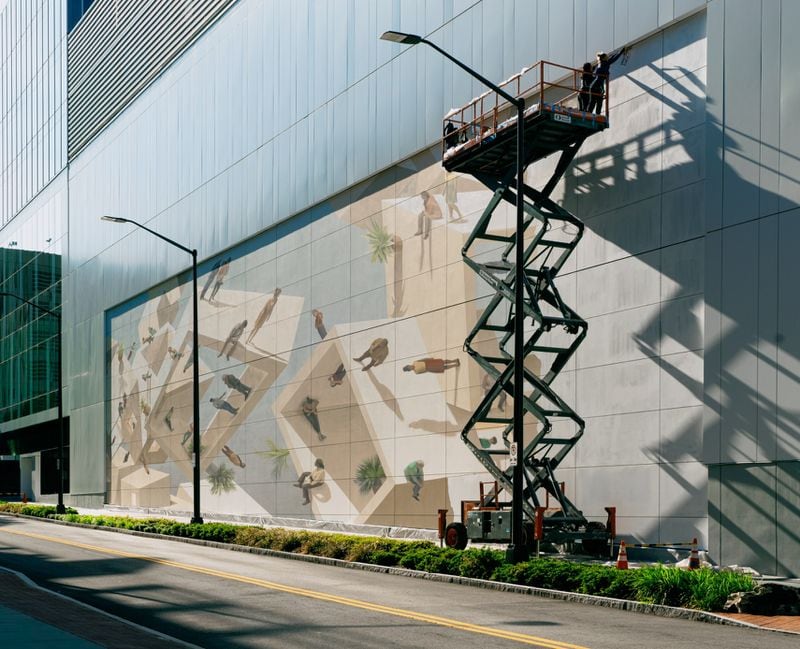 Artists Helena Salvador and Cinta Vidal worked 40 feet above Midtown on “Merge,” the streetscape mural that fills a wall of Coda Tech Square. 
Courtesy of Brock Scott/Living Walls