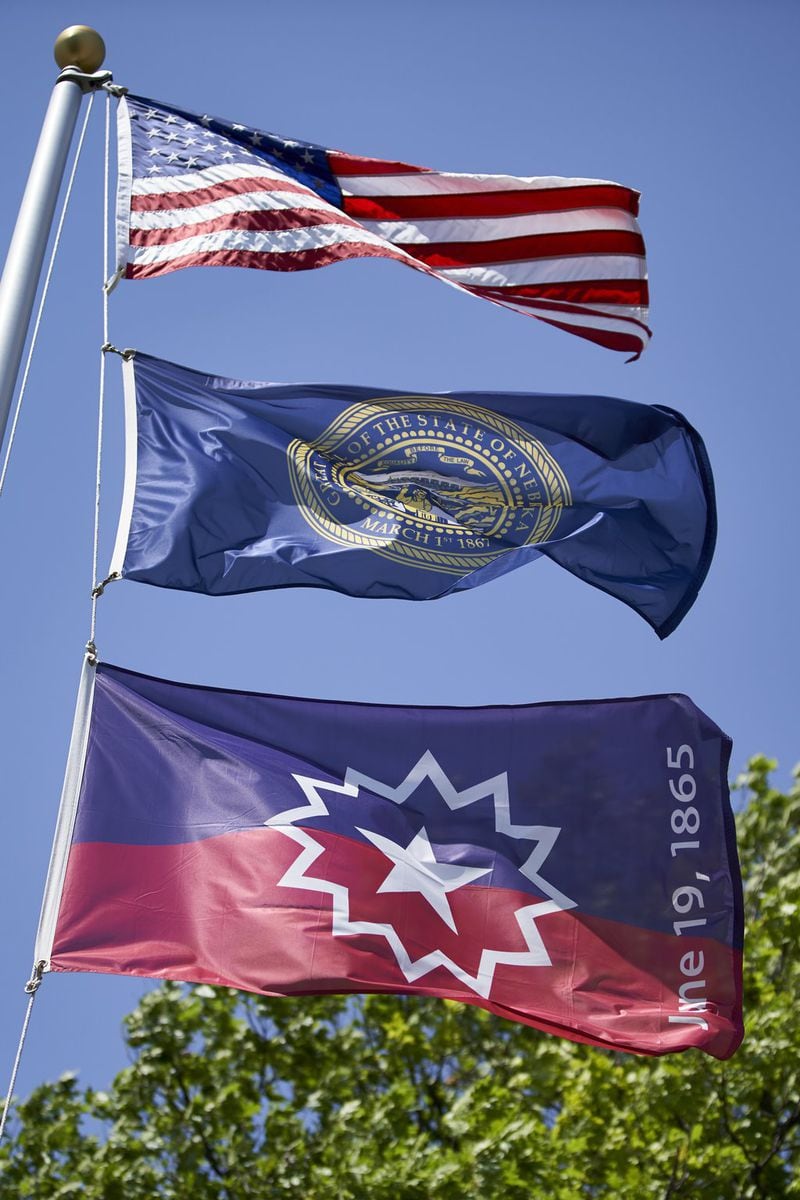 The Juneteenth flag, bottom, flies beneath the U.S. flag and the State of Nebraska flag in Omaha. The Juneteenth flag commemorating the day that slavery ended in the U.S. will fly over the Wisconsin Capitol for the first time in state history, Gov. Tony Evers announced Wednesday. (AP Photo/Nati Harnik)