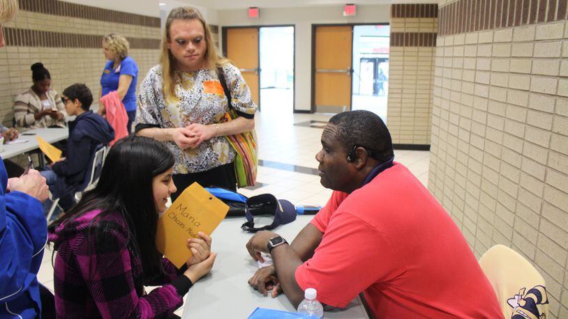 Vincent Martin, a visually-impaired graduate research assistant at Georgia Tech, speaks with Trickum Middle schooler Maria Chicas-Medrano during the district’s first career fair held at Parkview High specifically for visually-impaired students. Credit: Sue LaFave.