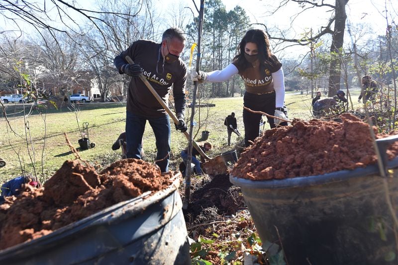Volunteers Dan Keim, left, and Cathy Scott plant a tree as part of a three-day effort to create a living tree tribute to memorialize the late Congressman John Lewis in Freedom Park in February 2021. (Photo: Hyosub Shin / Hyosub.Shin@ajc.com)