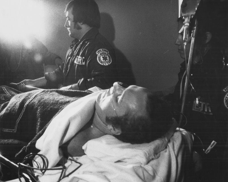 Hustler magazine publisher Larry Flynt is carried into Emory Hospital by EMTs on March 9, 1978. Flynt, shot in the abdomen, was taken on the day of the shooting, March 6, to Button Gwinnett Hospital, where he underwent surgery. Doug Campbell, Flynt's personal administrator, said "Physically, he's in a precarious position right now and he's aware of that."