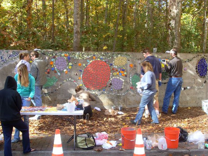 Forest trees can be seen as students, parents and teachers for Roswell Arts Renaissance worked to create a mosaic on the stormwater detention pond wall on Forrest Street in Roswell in 2009. City crews removed 50 trees in 2021 to expand the pond. Courtesy Facebook