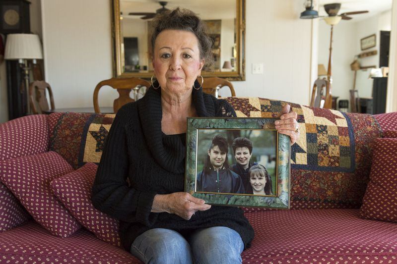 Mary Bernier, 67, holds a photo of her niece Stephanie, her sister Kate and niece Mary Beth Cyr in her home in Blairsville, Ga., on Nov. 16, 2016. Kate and Mary Beth were both diagnosed with ovarian cancer and died at the ages of 39 and 35, respectively. They both possessed a gene that increased the odds of contracting ovarian cancer. Stephanie does not have the gene, but Bernier does. DAVID BARNES / DAVID.BARNES@AJC.COM