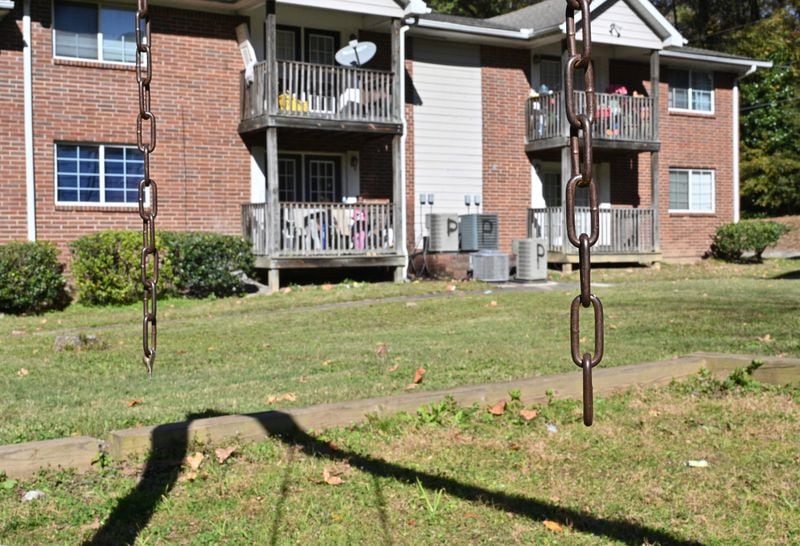 At Pavilion Place apartments in south Atlanta, in the playground in a complex that 103 school-age children list as their home address, a scrap two-by-four plank served for a time as a makeshift swing seat. Now, two bare chains dangle from an overhead bar, with no seat at all. (Hyosub Shin / hyosub.shin@ajc.com)