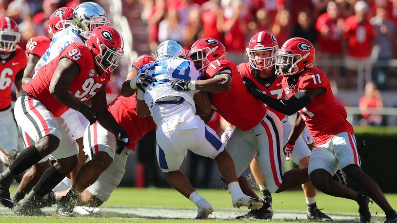 Georgia defenders smother Kentucky running back Chris Rodriguez to bring up third-and-16 on Saturday at Sanford Stadium. “Curtis Compton / Curtis.Compton@ajc.com”