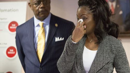 Fulton County District Attorney Paul L. Howard Jr (left) listens as Monteria Robinson talks about the death of her son Jamarion Robinson. Howards announced the filing of a lawsuit against the United States Department of Justice in the death of her son during a press conference on December 28th, 2018. (Photo by Phil Skinner)