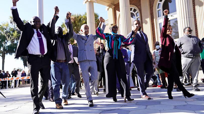 The Rev. Al Sharpton, third from the left, holds hands with Ahmaud Arbery‚Äôs parents, Wanda Cooper-Jones, right, and Marcus Arbery, left, as they react outside the Glynn County Courthouse in Brunswick, Ga., on Wednesday, Nov. 24, 2021, after the jury found three men guilty of murder and other charges for the pursuit and fatal shooting of Ahmaud Arbery. (Nicole Craine/The New York Times)