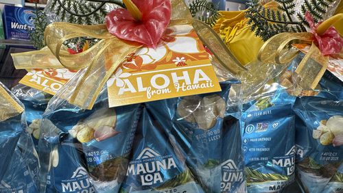 Packages of macadamia nuts are displayed on store shelves on Friday, April 26, 2024, in Honolulu. For decades, tourists to Hawaii have brought home gift boxes of the islands' famous chocolate-covered macadamia nuts for friends and family. (AP Photo/Audrey McAvoy)