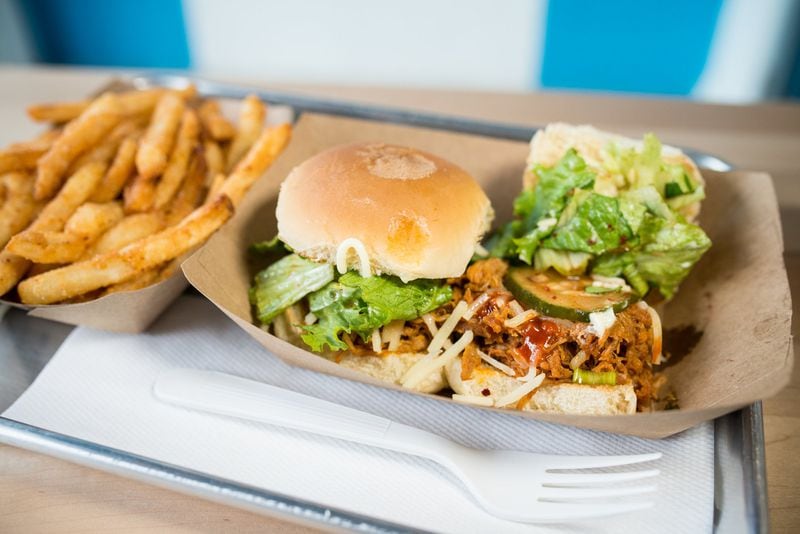  Yumbii Sliders with spicy pulled pork, cucumber kimchi, soy-sesame vinaigrette salad, sesame mayo, and shredded cheese, with side sesame fries. Photo credit- Mia Yakel.