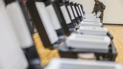 November 8, 2016 Atlanta: Poll manager Melvin Davis Jr. prepares voting machines on Tuesday, Nov. 8, 2016 at Henry W. Grady High School in Atlanta. JOHN SPINK /JSPINK@AJC.COM