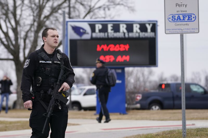 FILE - Police respond to Perry High School, Jan. 4, 2024, in Perry, Iowa. Iowa's Republican-led Legislature passed a bill this week allowing teachers and staff who undergo training to get permits to carry guns on school property. That comes three months after a fatal shooting at the Iowa school. (AP Photo/Andrew Harnik, File)