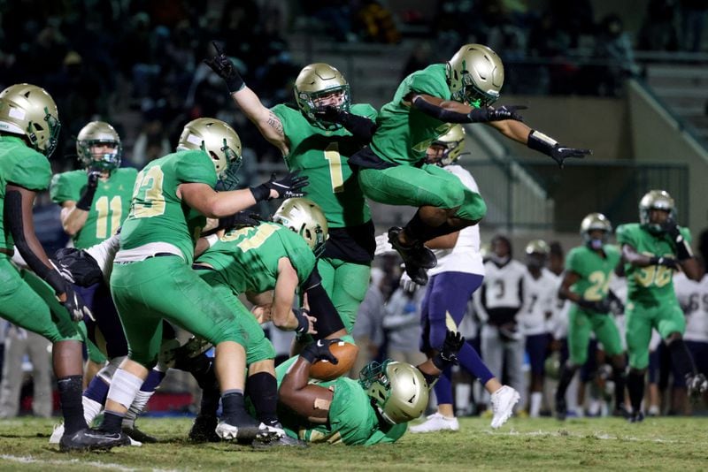 Big play for Buford: Defenders Tommy Beuglas (1) and Amari Wansley (2, jumping) react after Buford defensive lineman Malik Cunningham (with the ball on the ground) caught a tipped pass for an interception in the second half of Friday's game against Dacula.