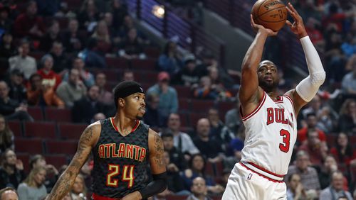 Chicago Bulls guard Dwyane Wade (3) shoots, scores and is fouled on the play by Atlanta Hawks forward Kent Bazemore (24) during the first half of an NBA basketball game, Wednesday, Jan. 25, 2017, in Chicago. (AP Photo/Kamil Krzaczynski)