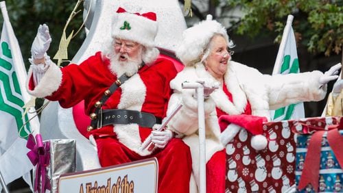 Mr. and Mrs. Santa Claus wave to the crowd during the Children's Christmas Parade Saturday, December 03, 2016, in Atlanta.