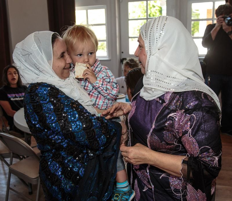 Hayat Ibrahim (R) and Saadia Kelli (L) fuss over Leonardo Garcia-Ide at a luncheon organized by local American military veterans and Atlanta-area Syrian refugees Sunday in Clarkston, GA April 9, 2017. STEVE SCHAEFER / SPECIAL TO THE AJC