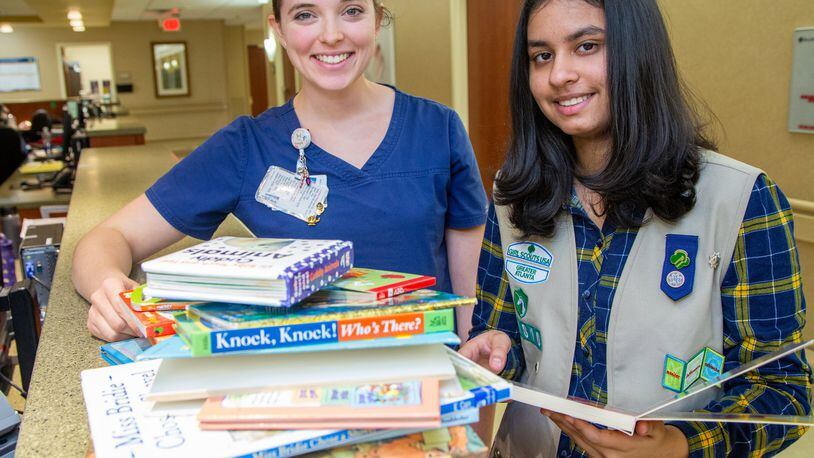 Anoushka Talwar (right) goes through some of the books she put in a library for parents of preemies with NICU nurse Gabrielle John at Emory Johns Creek Hospital. She created libraries at two metro Atlanta hospitals NICUs as a Girl Scout project. She has a passion for preemies, both she and her brother weighed in under three pounds. (Photo by Phil Skinner)