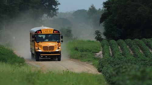 A Wilcox County school bus travels down a dirt road next to rows of cotton in  the south Georgia region. Are donors giving enough time and money to rural and small-town schools throughout Georgia?
