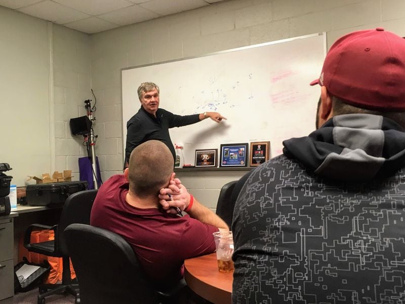 Former Georgia Tech coach Paul Johnson shows Lassiter High coaches a play out of his spread-option offense in a meeting at the school December 9, 2019. (AJC photo by Ken Sugiura)