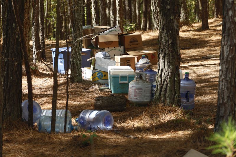 Empty boxes, water containers and propane tanks sit in the midst of forested land that is the proposed site of Cop City as seen on Friday, October 21, 2022. (Natrice Miller/natrice.miller@ajc.com)  


