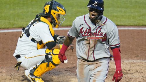Braves' Orlando Arcia (right) returns to the dugout after hitting a solo home run off Pittsburgh Pirates starting pitcher Chad Kuhl in the fifth inning Tuesday, July 6, 2021, in Pittsburgh. (Gene J. Puskar/AP)