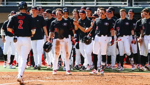 Members of the Georgia baseball team celebrate second baseman LJ Talley (2) as he reaches home Dayton Saturday, Feb. 16, 2019, at Foley Field in Athens.