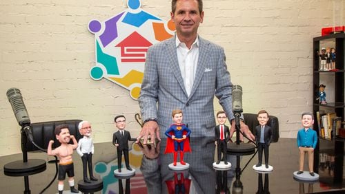 Supreme Lending CEO, Pat Flood, poses behind a group of bobblehead dolls that he has had made of the guests that appear on his monthly podcast at their Alpharetta offices. For the Top Workplaces section (Photo by Phil Skinner)