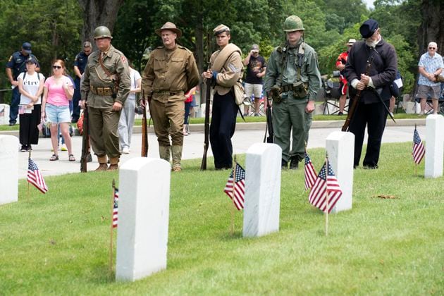 People dressed as military from different wars watch the Memorial Day ceremony at Marietta National Cemetery on Monday, May 27, 2024.  (Ben Gray / Ben@BenGray.com)