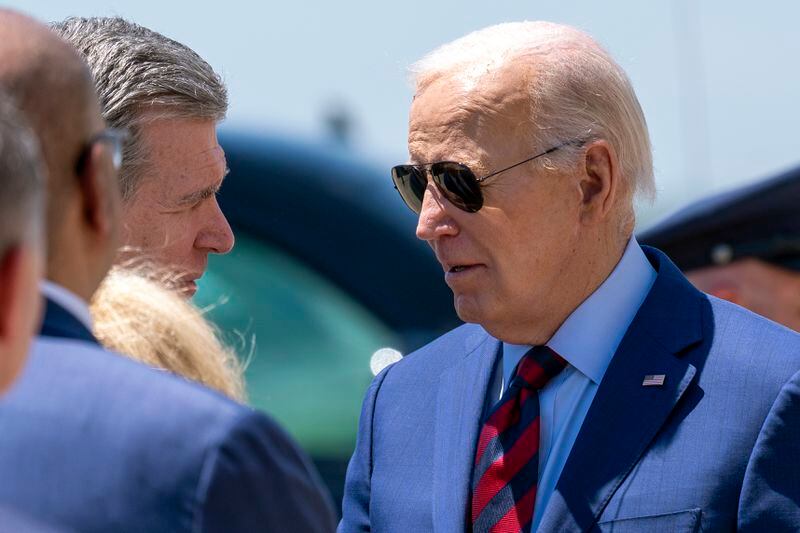 President Joe Biden is greeted by North Carolina Gov. Roy Cooper, left, as he arrives on Air Force One at Charlotte Douglas International Airport, Thursday, May 2, 2024, in Charlotte, N.C. Biden is meeting with the families of law enforcement officers shot to death on the job. (AP Photo/Alex Brandon)