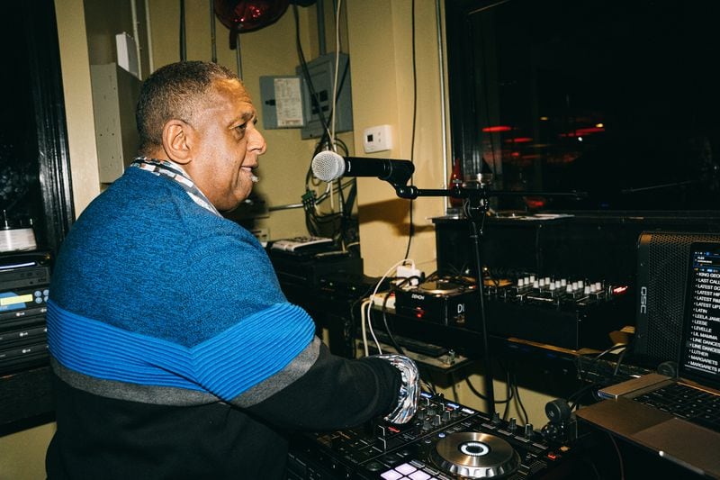 DJ, Chico Renfro age 73, mixes tracks at for seniors ages 55 and up at Ellery's Night Club and Lounge in southwest Atlanta on Wednesday, Feb. 21, 2024. (Olivia Bowdoin for the AJC).  