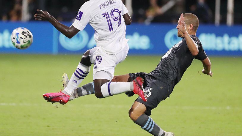 Orlando City's Benji Michel (19) leaps in front of Minnesota United's Osvaldo Alonso during the MLS is Back tournament at Disney's ESPN Wide World of Sports in Orlando, Florida, on Thursday, Aug. 6, 2020. Orlando City won, 3-1. (Stephen M. Dowell/Orlando Sentinel/TNS)