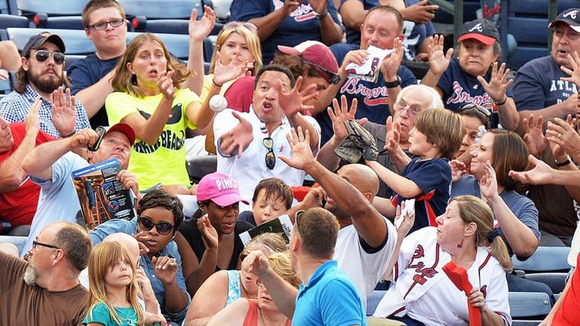 Fans react to a foul ball hit into the stands during a 2014 game at Turner Field. (BRANT SANDERLIN /BSANDERLIN@AJC.COM)