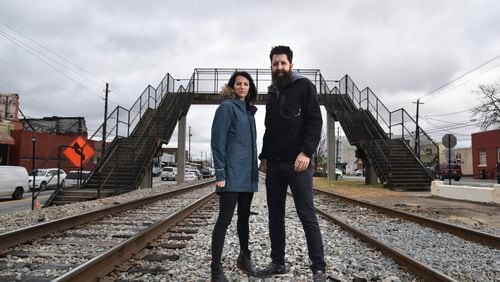 College Park residents Whitney (left) and Micah Stansell have been commissioned to tranform the Hapeville Pedestrian Bridge, visible in the background, into a public art installation. HYOSUB SHIN / HSHIN@AJC.COM