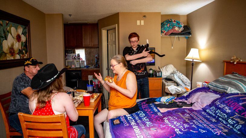 The Perdue family -- David, his wife Crystal, son Zachary, 15, and daughter Evangelene, 12, have dinner Friday, June 25, 2021 in their room at the Whits Inn, an extended stay hotel in Loganville where they live with Felix the cat and two ferrets. (Jenni Girtman for The Atlanta Journal-Constitution)