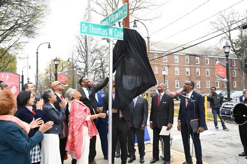 Clark Atlanta University officials, Atlanta Mayor Andre Dickens and family members of Thomas Cole unveil a new sign designating the street as Dr. Thomas W. Cole Jr. Way. (Courtesy of Clark Atlanta University)