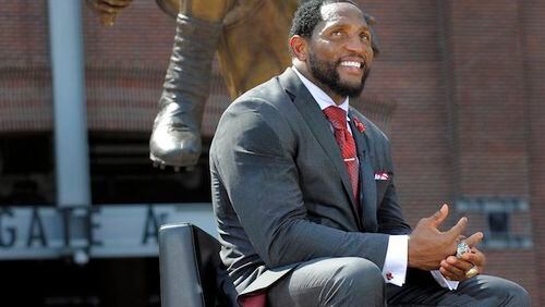 Ray Lewis sits in front of the bronze statue of himself that was unveiled at M&T Bank Stadium in Baltimore on Sept. 4, 2014. (Lloyd Fox/Baltimore Sun/TNS)