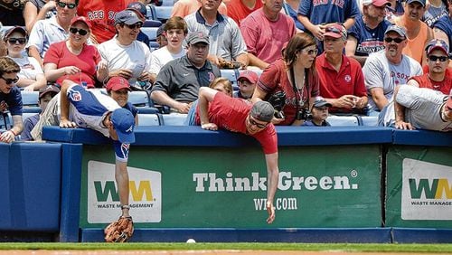 Fans reaching for fouls: The Braves argue that many fans choose field-level seats in the hope that a foul ball will come their way. BRANT SANDERLIN/bsanderlin@ajc.com