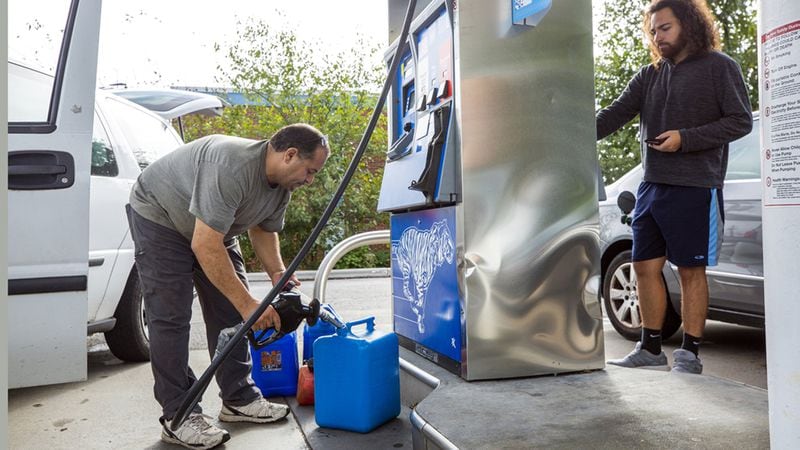 Tarek Elshik, left, fills gas cans to fuel a generator to refrigerate insulin for his 10-year-old daughter’s Type 1 diabetes treatment in case power goes out during Hurricane Florence. He and other motorists were at the Exxon station on Western Boulevard in Raleigh, N.C., on Tuesday, Sept. 11, 2018.