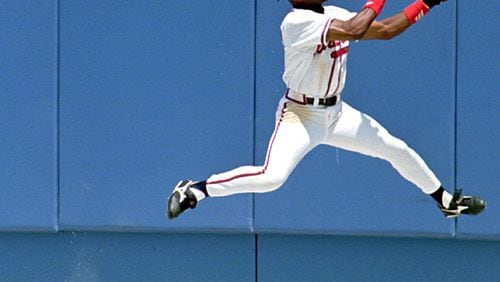 Braves’ center fielder Marquis Grissom makes a catch at the warning track to rob Chicago Cubs’ third baseman Leo Gomez of a hit May 22, 1996.(AP Photo/Andrew Innerarity)