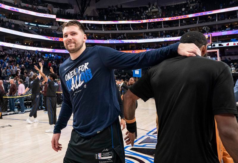 Dallas Mavericks' Luka Doncic, left, congratulates teammate Kyrie Irving as Irving speaks to the media after beating the Los Angeles Clippers 114-101 in Game 6 of an NBA basketball first-round playoff series Friday, May 3, 2024, in Dallas. (AP Photo/Jeffrey McWhorter)
