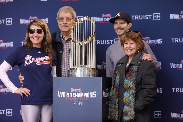 The Kantsios family, from Atlanta, stands beside the Braves World Champions Trophy during the first stop of the trophy tour at Colony Square in Midtown on Tuesday, February 15, 2022. Miguel Martinez for The Atlanta Journal-Constitution 