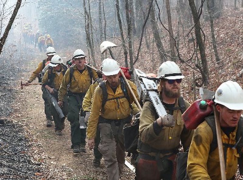 A California fire crew (right) walks in as an Oregon crew (left) heads out while battling the Rock Mountain fire. CURTIS COMPTON / CCOMPTON@AJC.COM