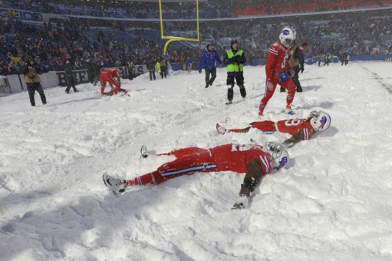 Buffalo Bills players make snow angels after beating the Indianapolis Colts after an NFL football game, Sunday, Dec. 10, 2017, in Orchard Park, N.Y. The Bills beat the Colts in overtime 13-7. (AP Photo/Adrian Kraus)