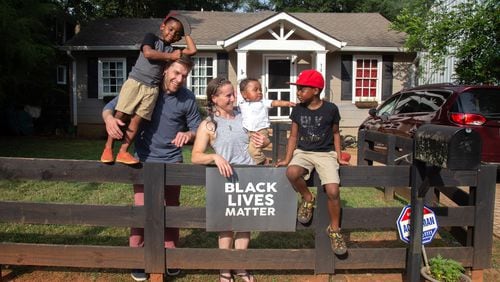 Zach and Brit Eyster and their three children - Mac (standing on fence); Cyrus (baby) and Clark (red hat) - pose for a photograph in front of their Decatur on home July 15, 2020. 
STEVE SCHAEFER FOR THE ATLANTA JOURNAL-CONSTITUTION