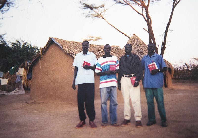 A photo of Abraham Deng Ater (left) and his friends and family in 2000 in the Kakuma Refugee Camp in Kenya is displayed at his residence in Snellville. Ater says he may have been 21 during this photo. 